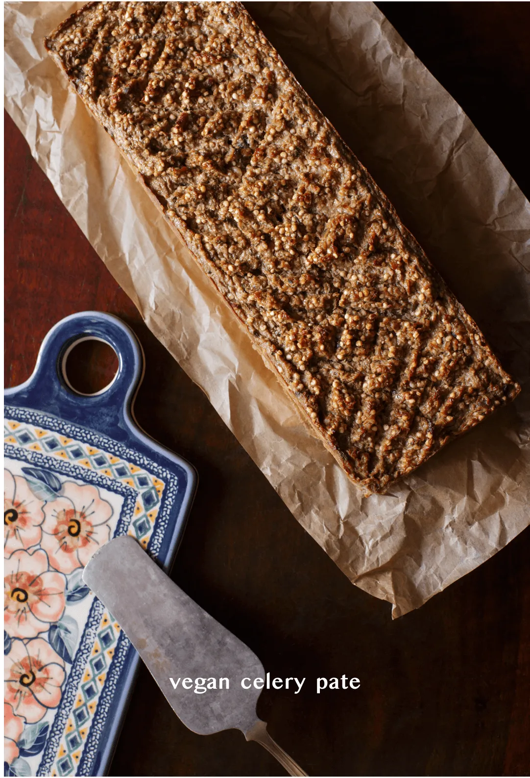 Seeded loaf of vegan celery pâté on a folk-pattern ceramic board, titled "vegan celery pate"