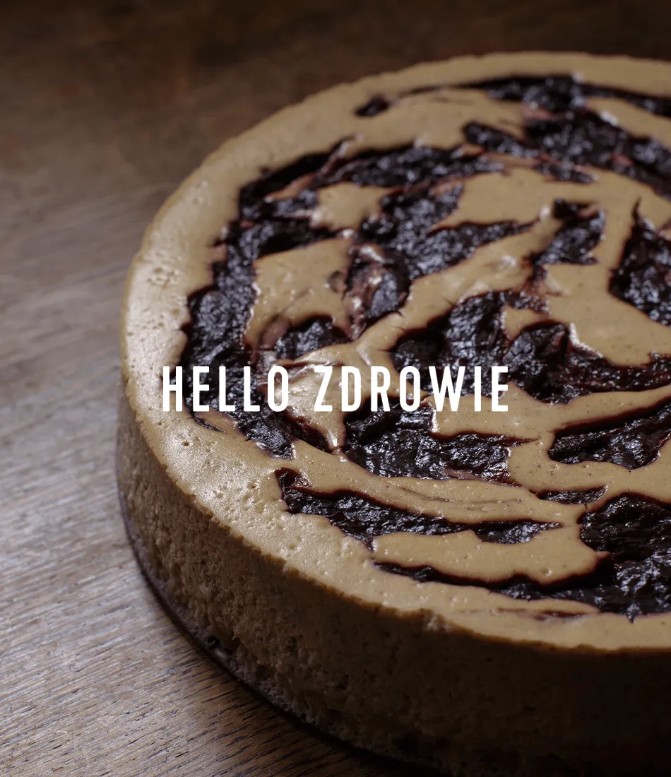 Cinnamon cheesecake marbled with plum jam on a dark table, with the Hello Zdrowie logotype overlaid