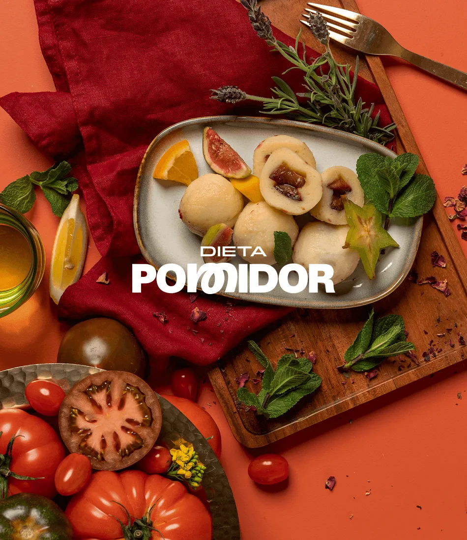 Overhead photo of a plate of dumplings with fig and star fruit on a red table among tomatoes and mint, with the Dieta Pomidor wordmark overlaid